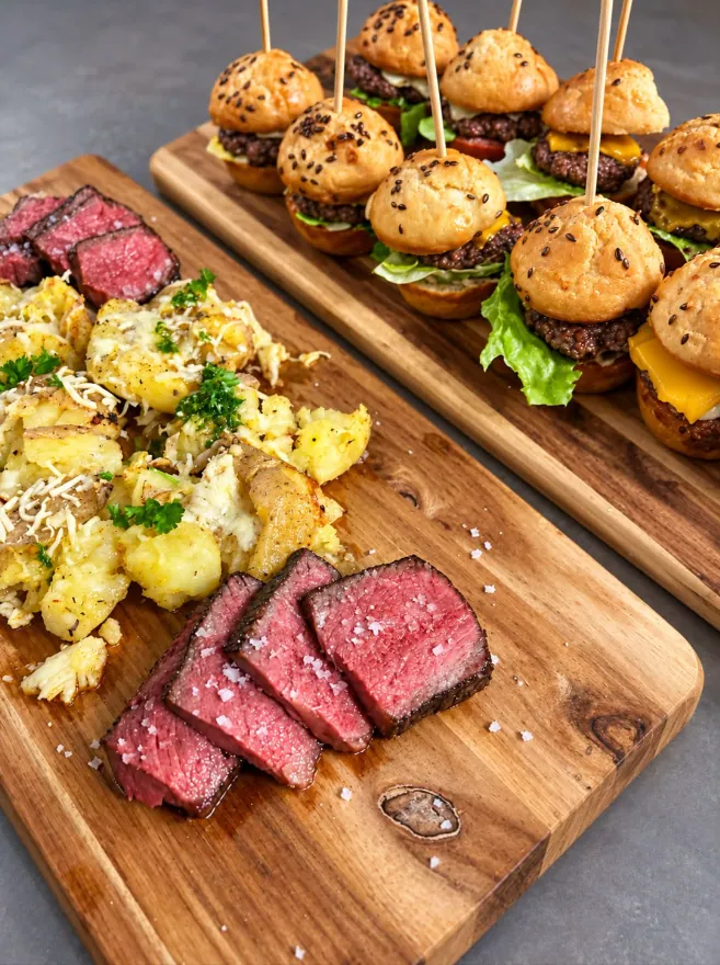 Mini burgerji in narezan steak na deskah
