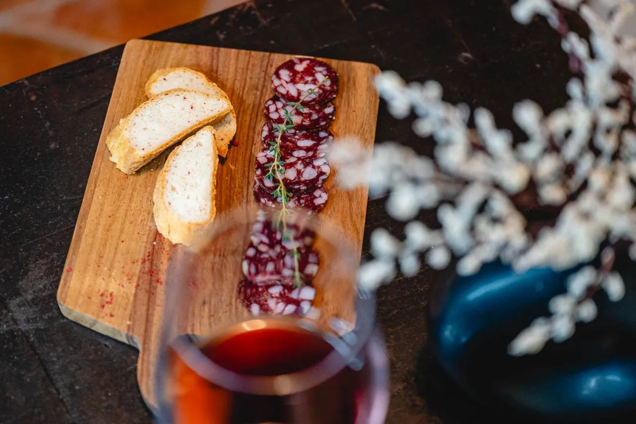 Brezglutenski kruh, hišna salama in kozarec vina na mizi